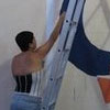 Okida pintando o logotipo